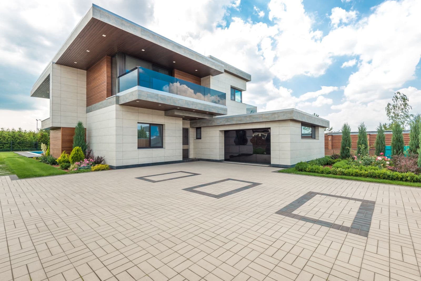A modern home with a large block-paved driveway