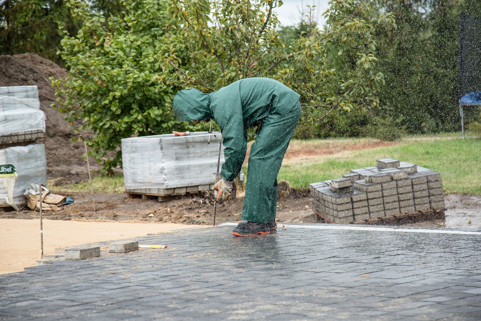 A Premier Drives groundworker laying block paving